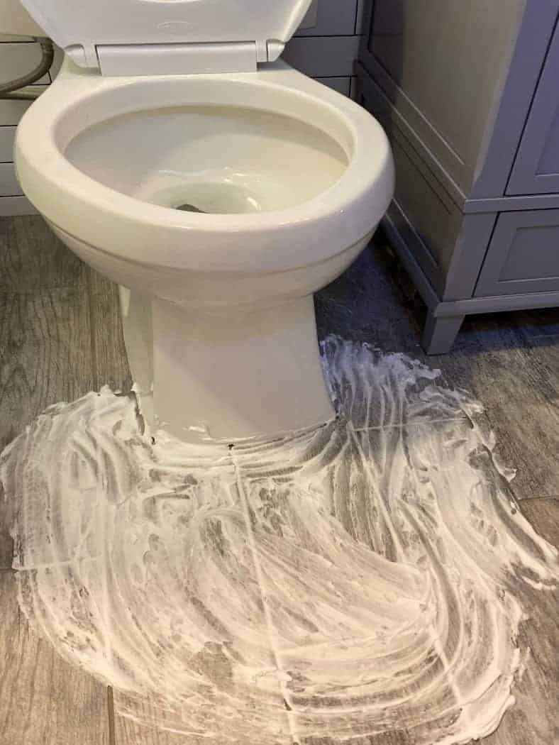 Toilet with shaving cream on floor to get rid of urine smell in a clean bathroom.