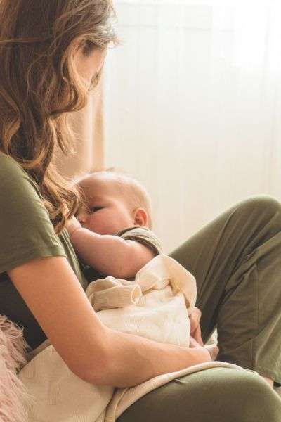 postpartum mom in pj's feeding baby