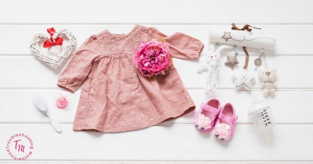 Strong Baby Girl Names with Powerful Meanings Blog Image of baby girl items like shoes, bottle, dress. 