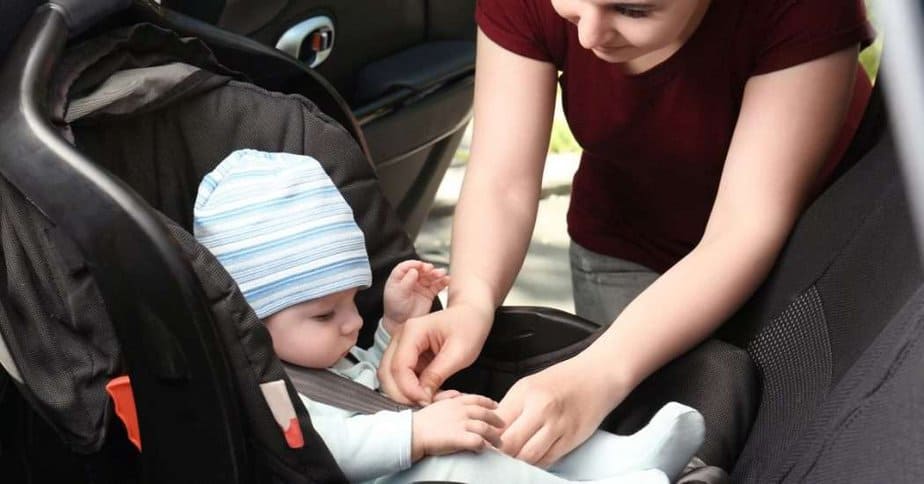 Best lightweight infant car seat. mom buckling baby into seat