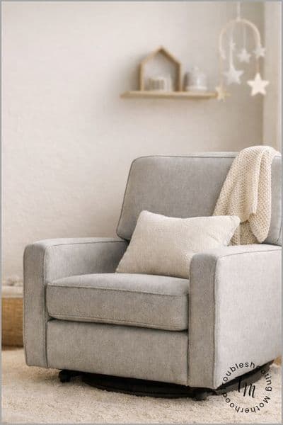 Small nursery with a compact upholstered nursery glider next to a crib, showing a space-saving nursing chair setup ideal for small nurseries and tight spaces