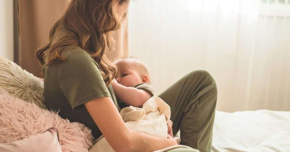 postpartum mom in pajamas nursing baby.