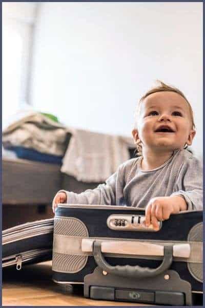 Best Travel Bassinet for babies. Image of baby sitting in a suitcase.