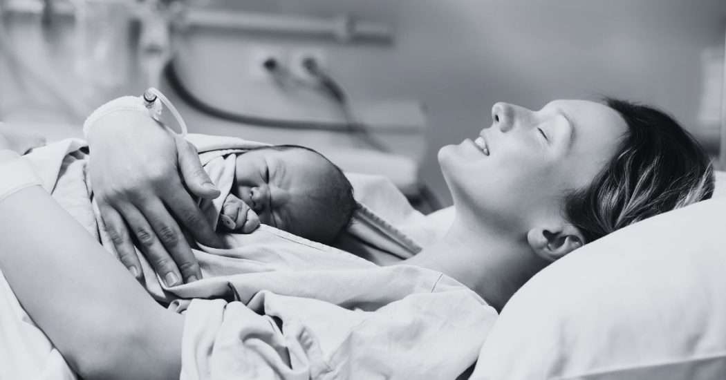 How to prevent tearing during childbirth. Image of woman in hospital gown with baby on her chest after just giving birth. 