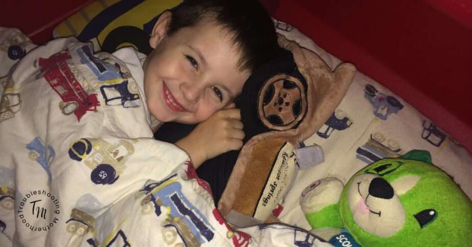 Help your kids fall asleep fast. Image of toddler boy laying in bed. Toddler bedtime, parenting tips.