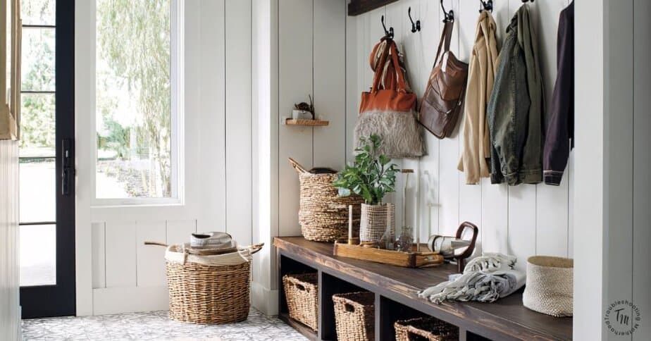 Bright entryway with wall hooks, backpacks, jackets, and shoe baskets showing a simple home reset system to keep a messy house organized